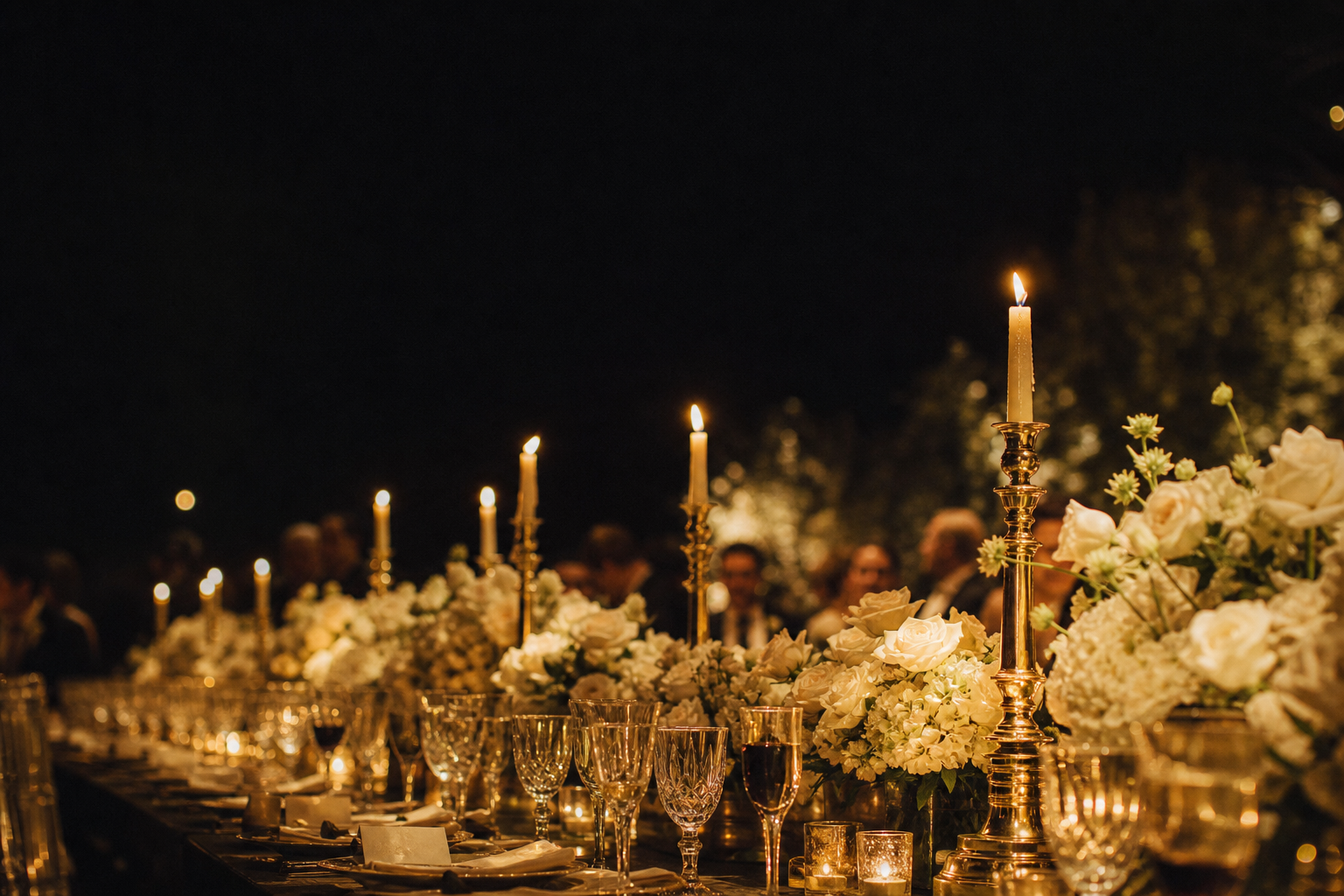 Mesa de jantar de casamento com castiçais dourados, velas e rosas brancas
